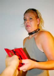 Blonde woman wearing a black collar and holding a red book.