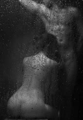  A woman and a man naked in the shower, kissing and making out.