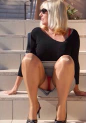 Woman sitting on stairs with her legs crossed.