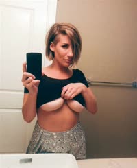 Busty Woman Taking Selfie in Bathroom Mirror