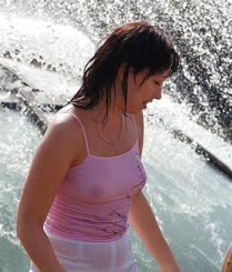 A woman in a pink shirt standing in the water.