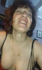  Woman wearing a black top and strapless bra with a gold necklace and a big nose taking a selfie