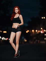 a beautiful woman standing on top of a road