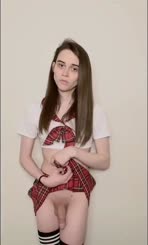 A woman wearing a school girl outfit and a black thong.